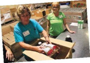Harry Chapin Food Bank volunteer Sharon Wilmoth tapes a food box that will be given to a senior in need.