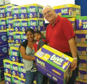 Baby Basics’ volunteer, Wayne Antworth, distributes diapers – and kindness – to one of the many families who participate in this important program.