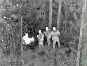 A screen grab from video taken from a high-definition camera onboard a Collier County Sheriff’s Office helicopter shows the moment three deputies found a 47-year-old man with Down syndrome who wandered away from his home in July 2014. Deputies in the sky guided deputies on the ground to the man’s location after the camera’s infrared thermal imaging system detected a heat signature in dense woods near the man’s residence in Golden Gate Estates. CCSO photo.