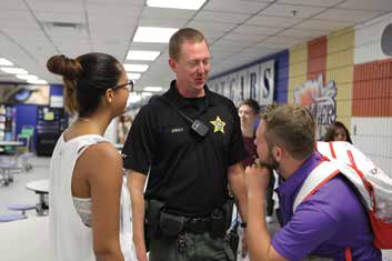 YOUTH RELATIONS BUREAU CPL. LUKE ARNOLD SHARES A SMILE WITH STUDENTS ON THE FIRST DAY OF CLASSES AT BARRON COLLIER HIGH SCHOOL.. CCSO YOUTH RELATIONS BUREAU WAS NAMED AGENCY OF THE YEAR FOR 2015 BY THE FLORIDA ASSOCIATION OF SCHOOL RESOURCE OFFICERS. PHOTO BY CPL. EFRAIN HERNANDEZ/CCSO